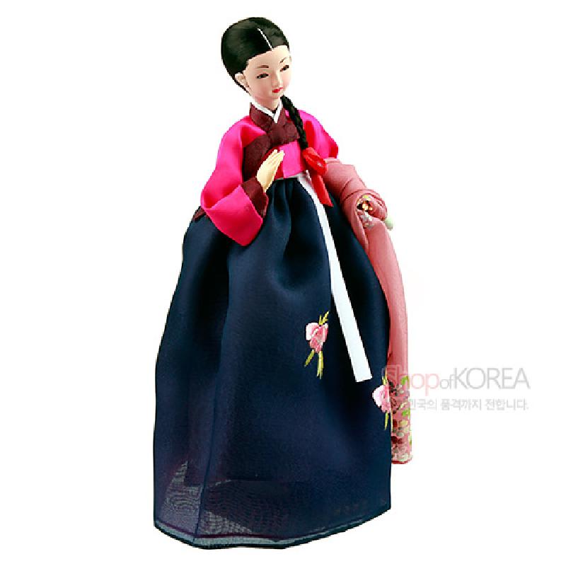 남색 치마와 분홍 저고리에 꽃 자수 문양이 놓인 한복 차림의 여성 인형 장식품.