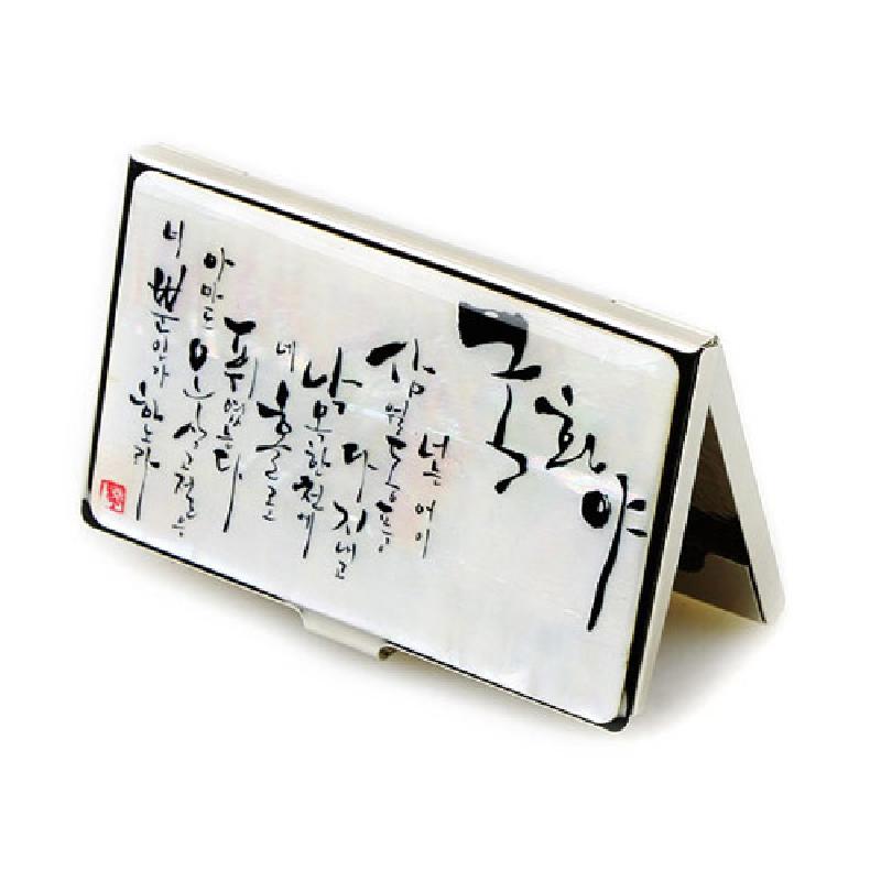 자개 판 위에 흑색 서예 글귀를 올린 은빛 금속 테두리의 직사각형 명함집.