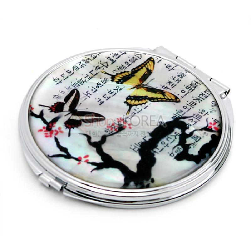 자개로 장식된 원형 금속 손거울, 매화나비와 매화 가지, 한글 서체 문양이 어우러진 다채로운 색감의 디자인.