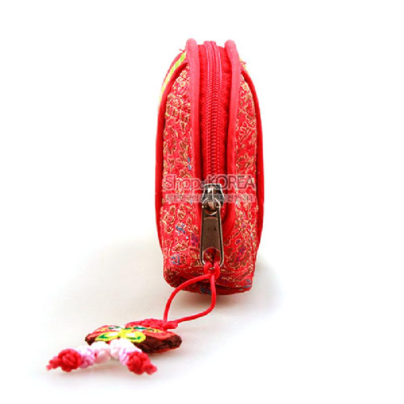 붉은 비단 위 전통 금사 자수 문양이 놓인 누비 동전지갑, 지퍼 장식과 색실 매듭 달이 포인트인 디자인.