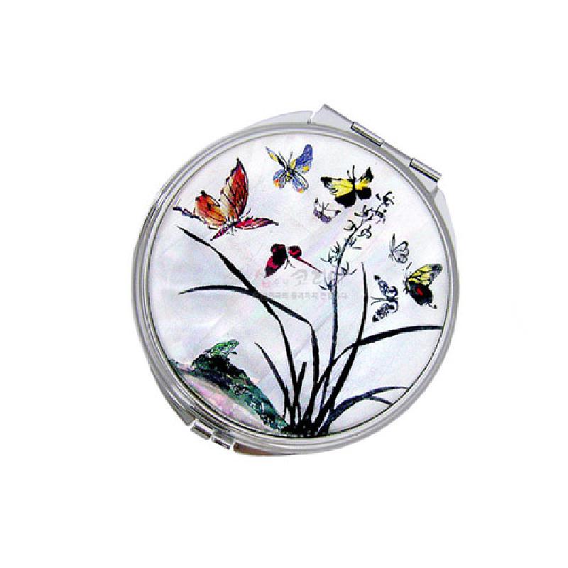 자개 바탕 위에 난초와 나비를 섬세한 채색으로 표현한 원형 금속 테두리 손거울.