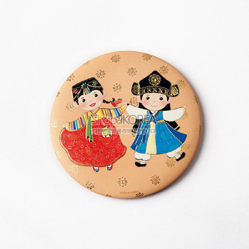 전통 예복을 입은 남녀 아이 캐릭터와 금색 꽃문양을 파스텔톤 배경에 담은 원형 손거울. 전통 예복을 입은 남녀 아이 캐릭터와 금색 꽃문양을 파스텔톤 배경에 담은 원형 손거울.