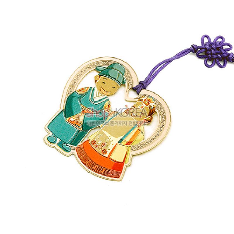 금속 재질에 혼례복 인물과 하트형 장식을 채색한 금장 책갈피, 보라색 전통 매듭끈 장식.