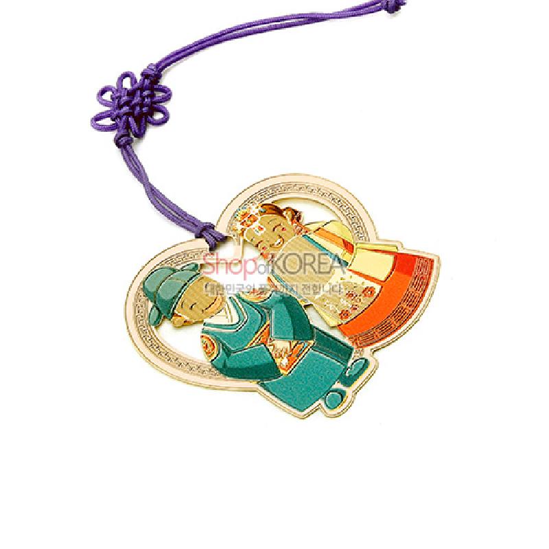 금속 재질에 혼례복 입은 신랑·신부 도안과 금장 테두리가 어우러진 책갈피, 보라색 전통 매듭끈 장식.