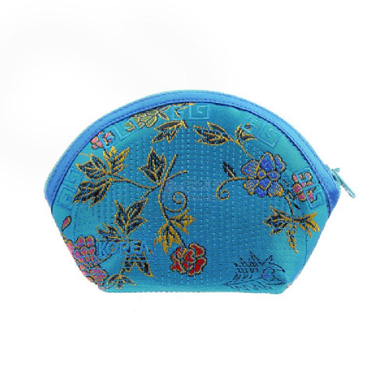 청색 비단 재질에 누비 기법을 적용하고 다채로운 꽃과 덩굴 문양을 수놓은 반원형 동전지갑.