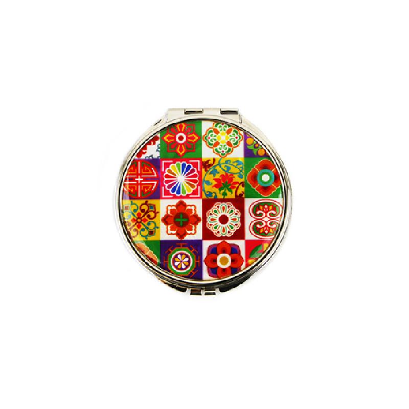 금속 테두리에 다채로운 색상의 전통 꽃문양과 기하학 문양이 격자 패턴으로 장식된 손거울. 금속 테두리에 다채로운 색상의 전통 꽃문양과 기하학 문양이 격자 패턴으로 장식된 손거울.