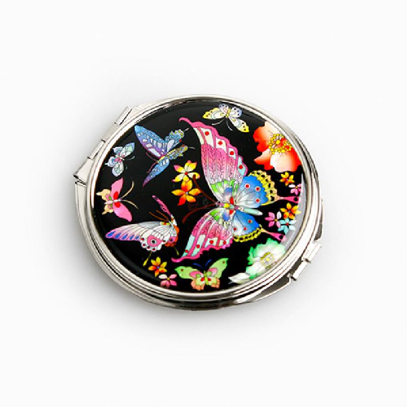 검은 옻칠 바탕 위 자개 상감으로 표현된 다채로운 호랑나비와 꽃문양이 특징인 금속 테두리 손거울. 검은 옻칠 바탕 위 자개 상감으로 표현된 다채로운 호랑나비와 꽃문양이 특징인 금속 테두리 손거울.