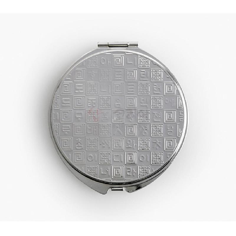 은색 금속 재질, 정사각 격자 안에 전통 문양과 문자 상감된 원형 손거울. 은색 금속 재질, 정사각 격자 안에 전통 문양과 문자 상감된 원형 손거울.