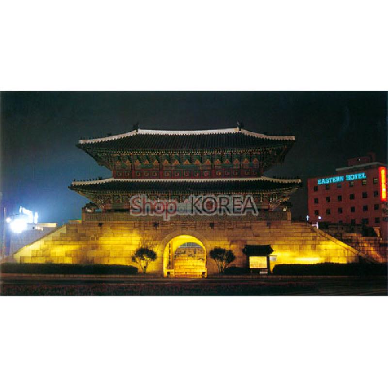 야간 조명 아래 석조 성곽과 기와지붕, 청록·적색 단청 문양이 대비되는 서울 도심 풍경 엽서. 야간 조명 아래 석조 성곽과 기와지붕, 청록·적색 단청 문양이 대비되는 서울 도심 풍경 엽서.