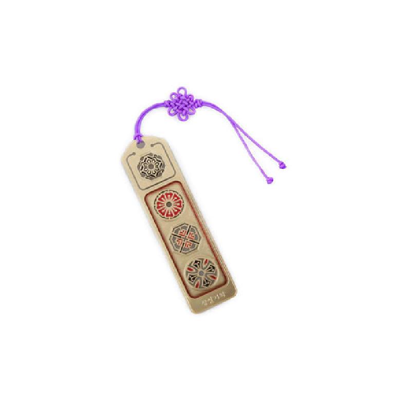 금속 재질 위에 붉은색과 검은색 창살기와 전통 문양을 상감한 장식, 보라색 매듭끈 장식의 책갈피.