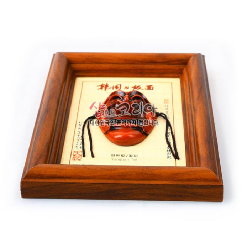 나무 재질 액자 속 붉은 갈색 옻칠 양반 하회탈 장식과 한지 바탕 서예 글씨가 조화를 이룬 인테리어 소품.