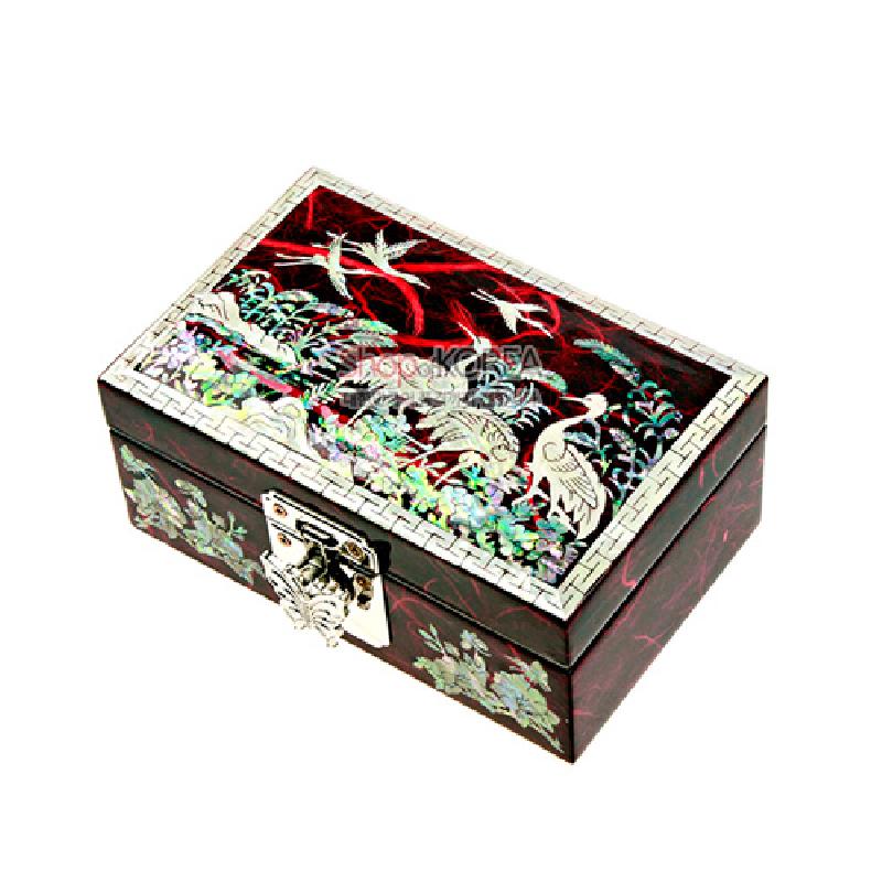 붉은 옻칠 바탕 위 자개 상감으로 군학과 송학, 화조 무늬를 표현한 직사각 보석함, 금속 잠금장식과 기하학 테두리 장식 특징.