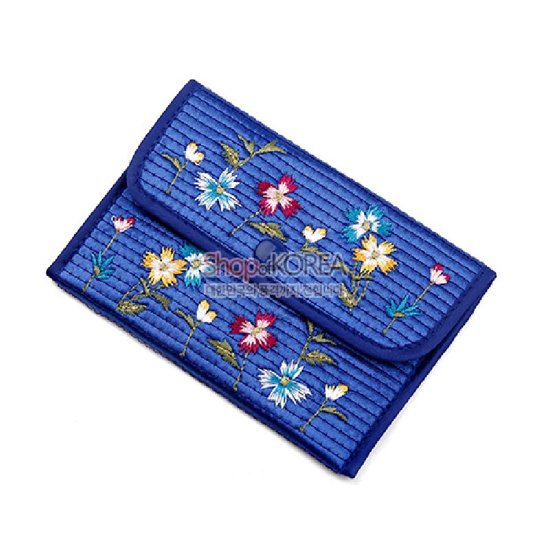 청색 누비 원단 위에 다채로운 색실로 수놓은 국화꽃과 줄기 문양이 특징인 동전지갑.