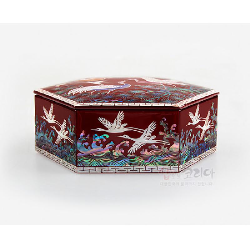 적색 옻칠 위 자개 상감 기법으로 송학과 파도, 구름 무늬를 표현한 6각 빈합.