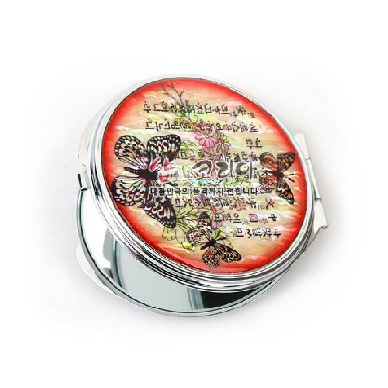 자개 상감 기법으로 표현한 나비와 꽃문양, 훈민정음 글귀가 어우러진 원형 금속 손거울. 자개 상감 기법으로 표현한 나비와 꽃문양, 훈민정음 글귀가 어우러진 원형 금속 손거울.