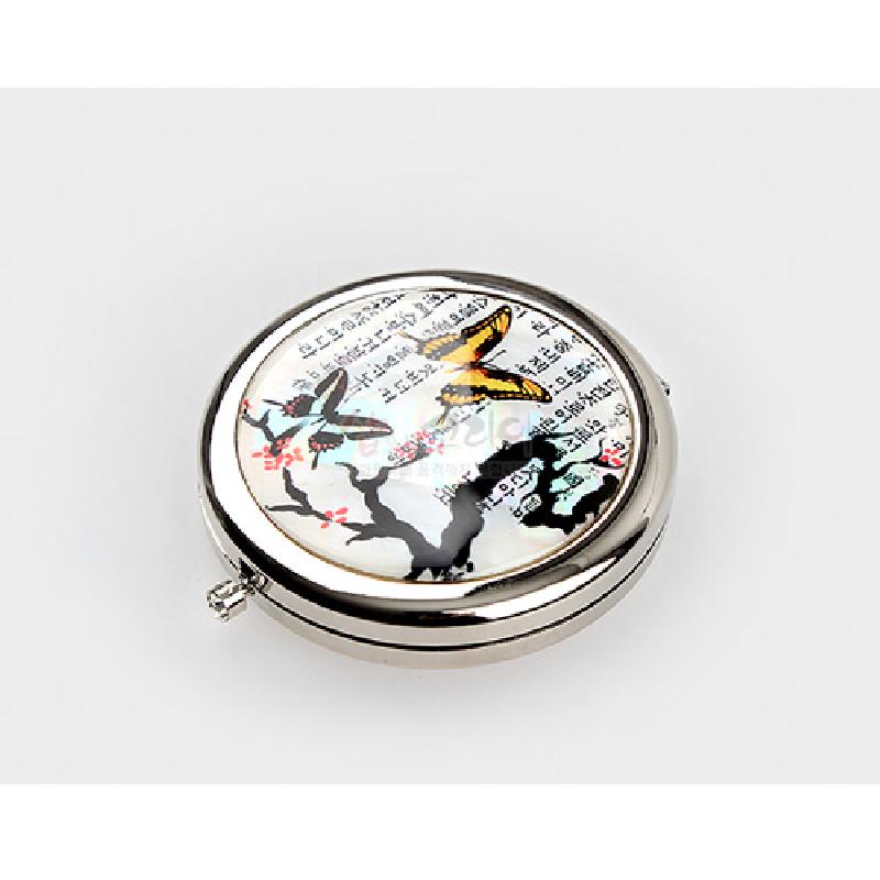 자개 상감 기법으로 매화나비와 한글 서체 문양을 장식한 원형 금속 손거울.