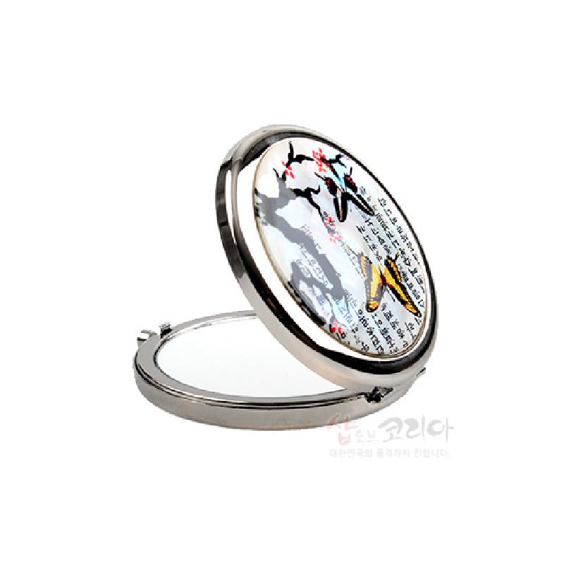 은색 금속 테두리에 자개 장식을 더하고 매화와 나비, 한글 서체 문양을 넣은 원터치 접이식 손거울.