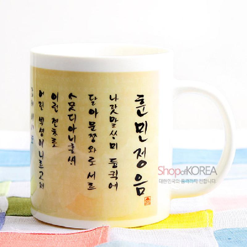 훈민정음 서예문과 붉은 낙관이 인쇄된 아이보리색 도자기 머그컵.