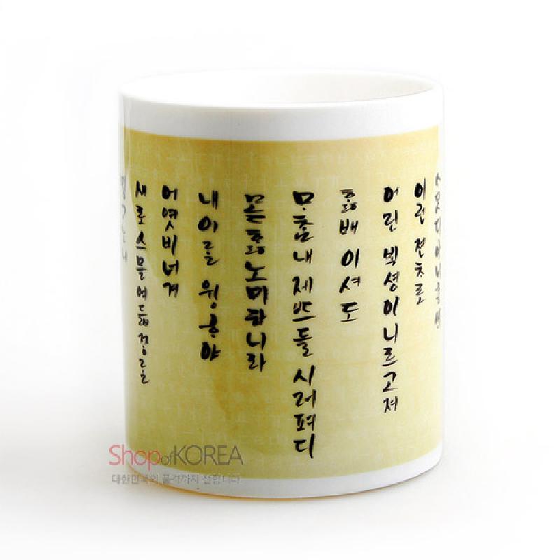 아이보리 바탕 위 훈민정음 서체가 인쇄된 도자기 머그컵.