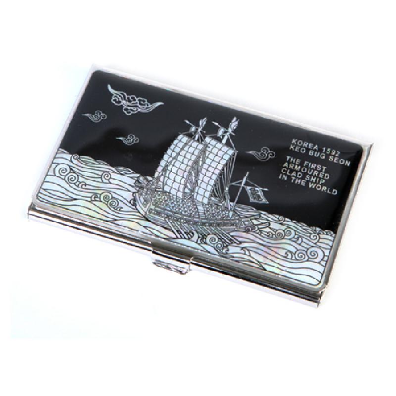 검은 바탕에 자개 상감 기법으로 거북선과 파도, 구름 문양을 표현한 금속 테두리 명함집.