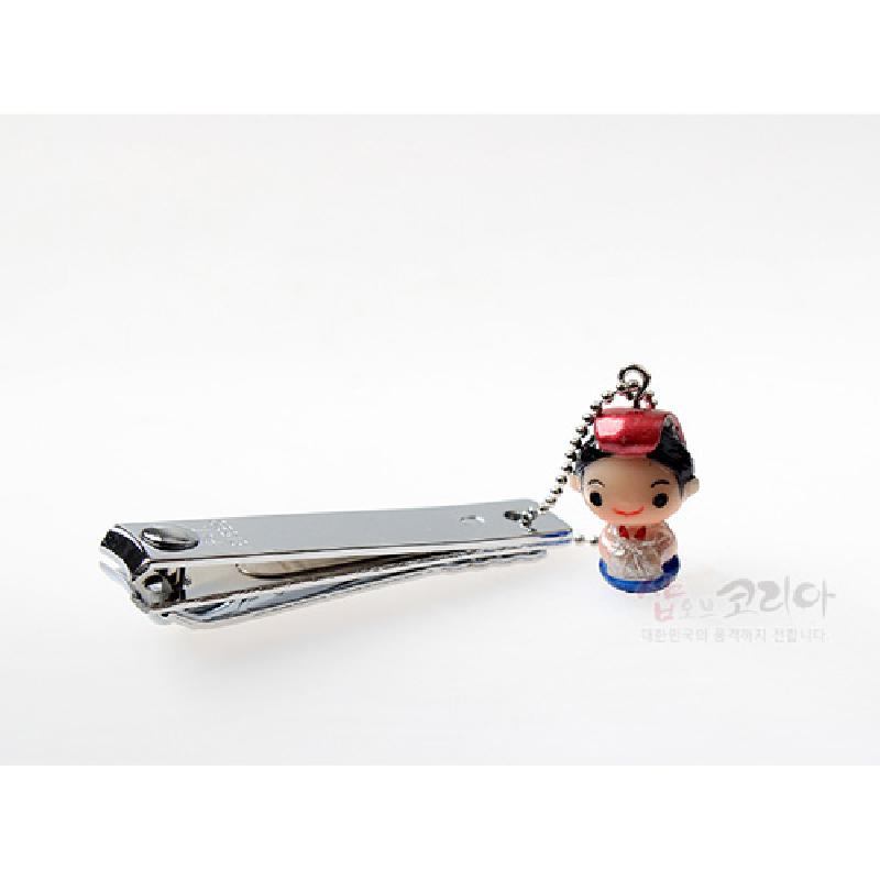 은색 금속 손톱깎이에 전통 한복 차림 인형 참이 연결된 장식형 손톱깎이.