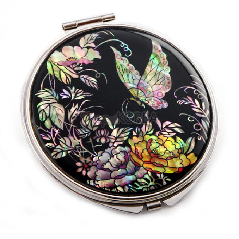 나전칠기 손거울의 측면 각도. 은색 금속 테두리와 검은 바탕 위 자개 상감의 입체적 질감.