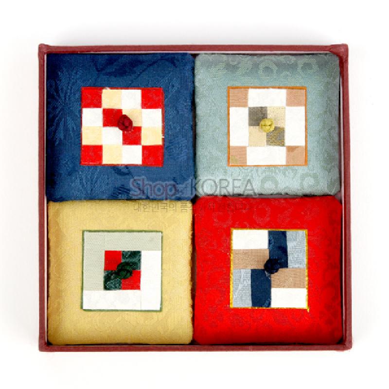 비단 재질 위에 전통 조각보 기법으로 사각 패턴을 구성한 다채로운 색상의 자석 장식.