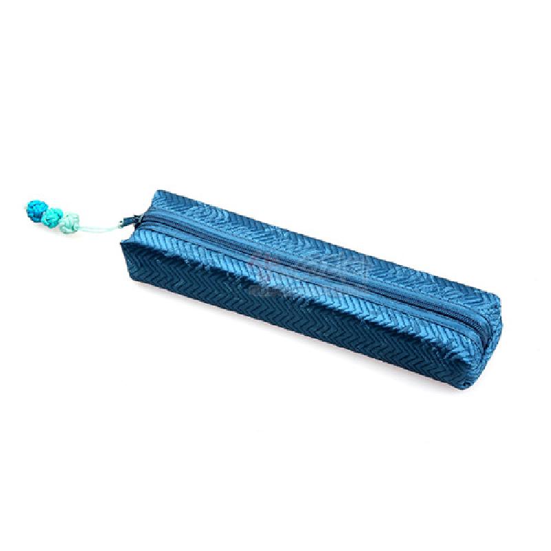 청색 누비 원단으로 제작된 필통, 지그재그 패턴과 배색 매듭 장식 지퍼 고리가 돋보이는 디자인.