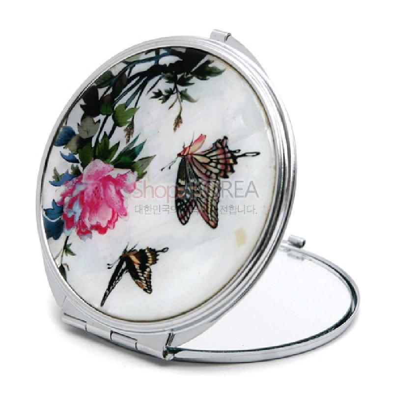 자개 바탕 위에 꽃과 나비 문양을 섬세한 채색으로 표현한 은색 금속 테두리 손거울.