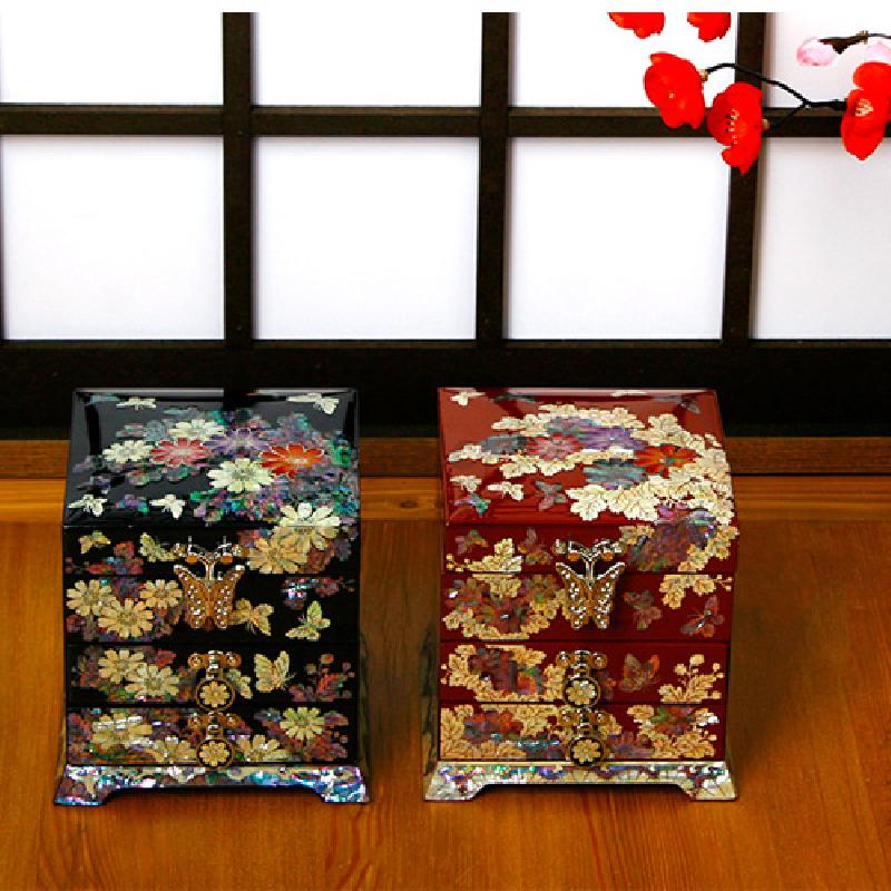 흑색 옻칠 바탕에 자개 상감으로 국화와 나비 문양을 섬세하게 표현한 금속 장식 2단 서랍함.