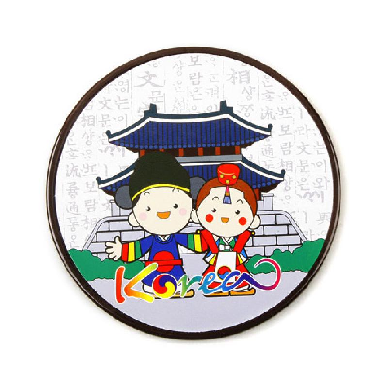 원형 목재 컵받침에 한복 입은 캐릭터와 전통 건축, 한글 배경이 어우러진 다채로운 색상의 민속화 장식.