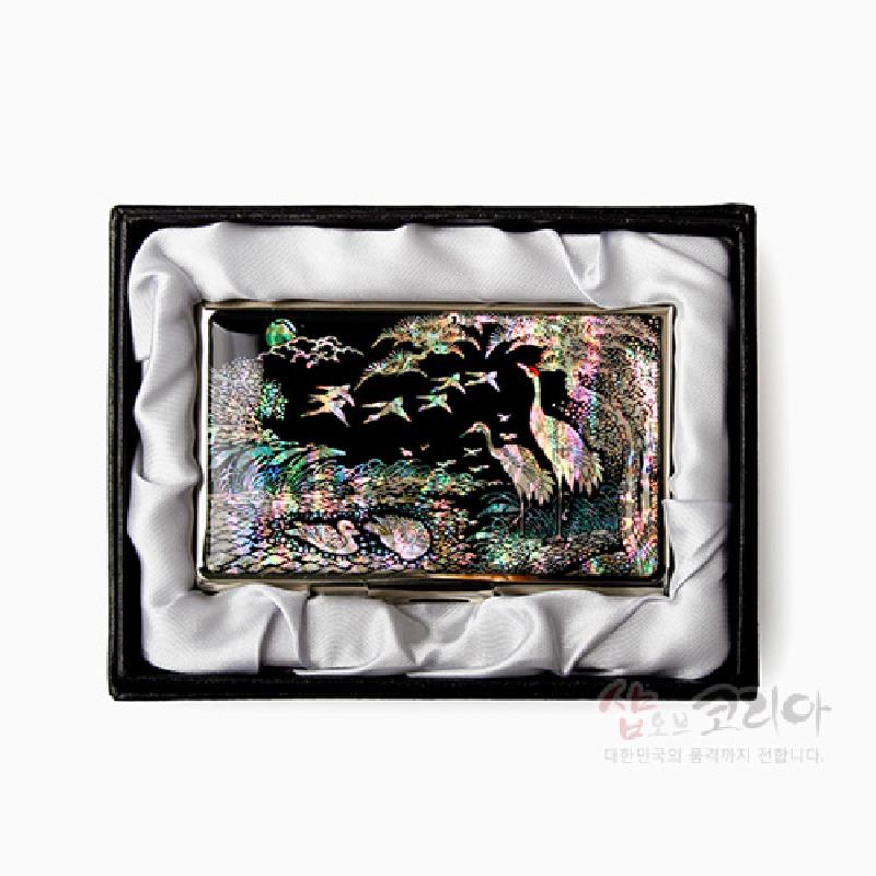 자개 상감 기법으로 학과 소나무, 연못 풍경을 묘사한 흑색 바탕 금속 명함집.
