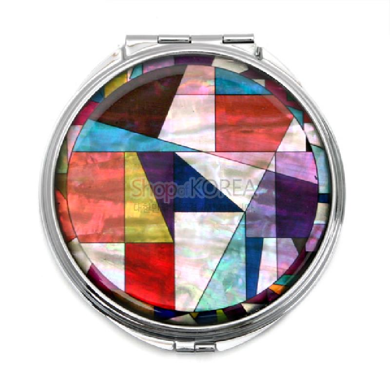 자개 상감 기법으로 표현된 조각보 기하학 문양과 다채로운 색감이 돋보이는 금속 손거울.