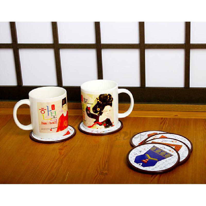 한복 문양을 그래픽으로 표현한 원형 컵받침, 화이트 바탕에 청색·적색 등 다채로운 색상의 인쇄와 나무 테 두름이 특징인 제품.