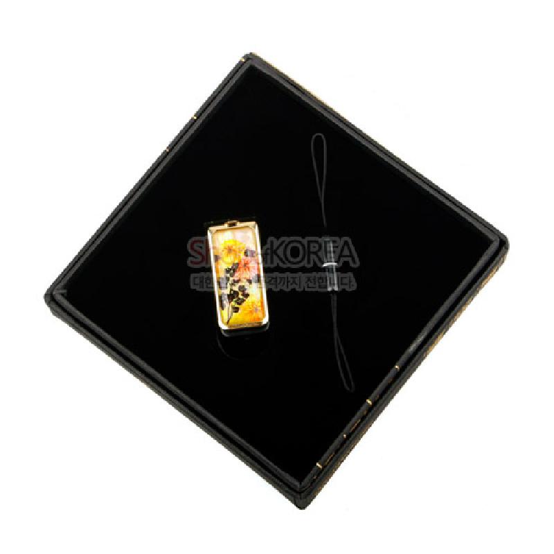 자개 상감 기법으로 국화 문양을 넣고 옻칠 마감한 금속 USB 메모리 장식.