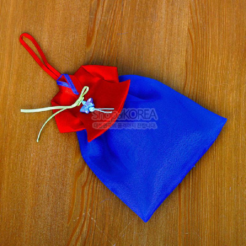 청색 치마와 붉은 당의 형태의 비단 향주머니, 노란 끈 매듭과 작은 꽃장식이 어우러진 전통 벽걸이 장식.