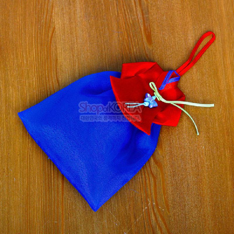 청색 치마와 홍색 당의 형태의 비단 향주머니, 대비색 끈 장식과 작은 매듭 장식이 돋보이는 전통 벽걸이 장식.