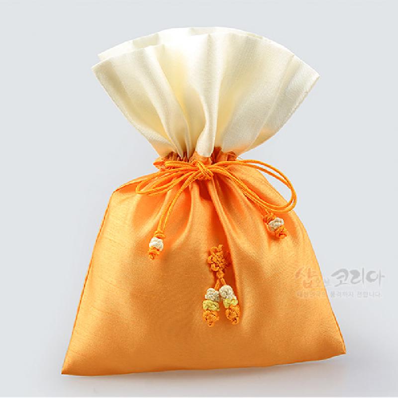 노란색과 아이보리색 비단 소재, 전통 매듭 끈과 매듭술 장식이 특징인 복주머니형 주머니.