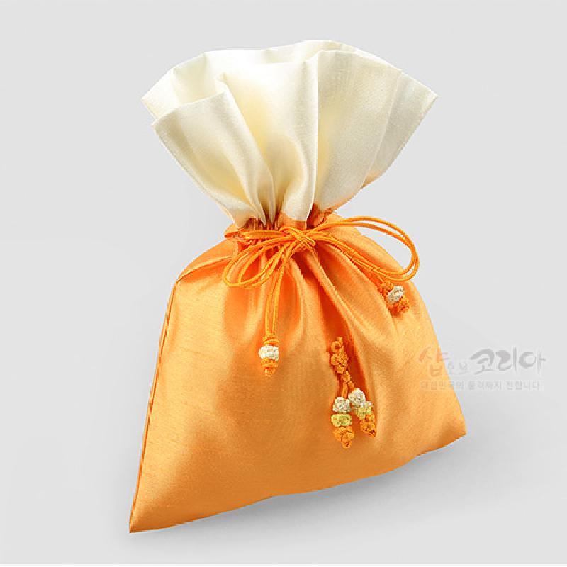 노랑빛 비단 재질에 상단 아이보리 색 대비, 전통 매듭 장식이 더해진 복주머니형 주머니.