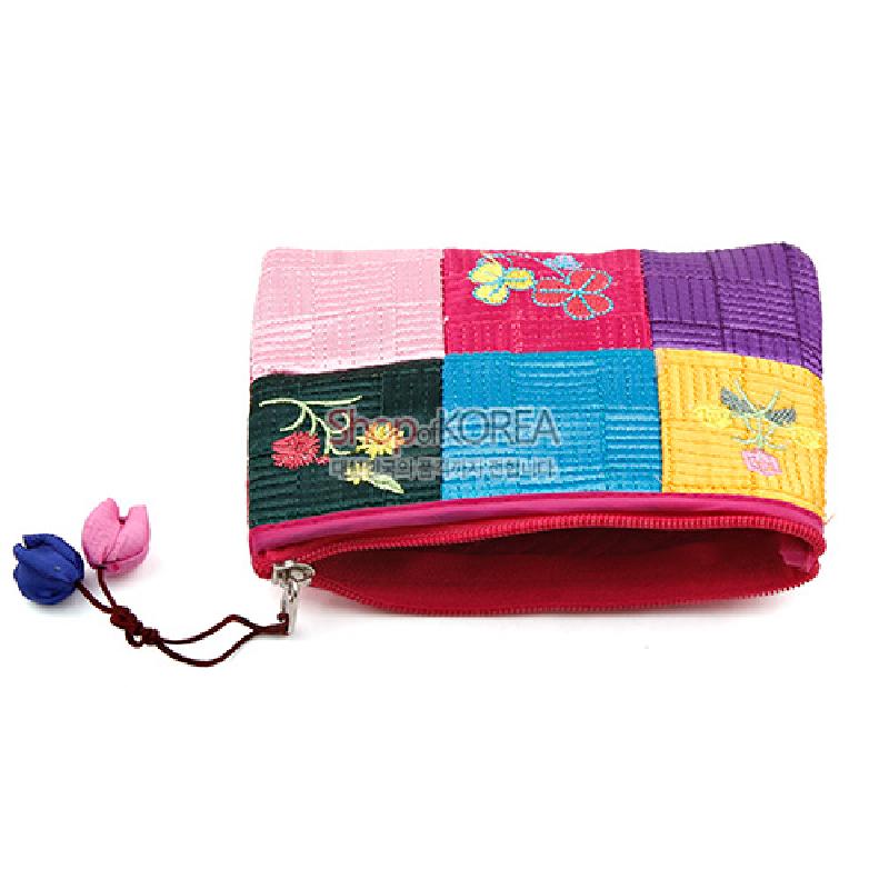 비단 소재의 누비 패치워크 바탕에 꽃 자수 문양이 수놓인 다채로운 색상의 동전 지갑.