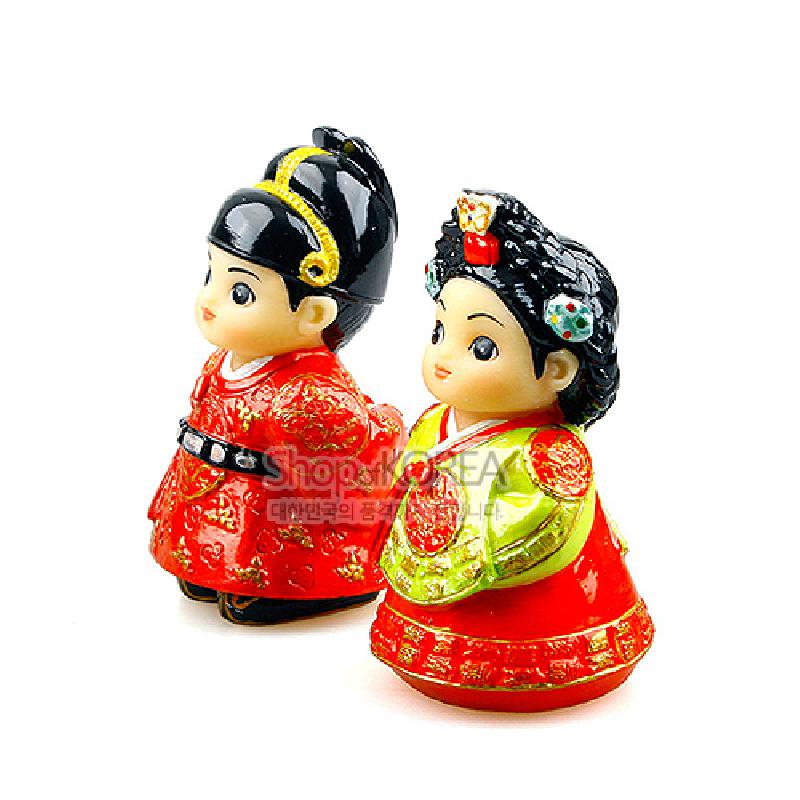 붉은색·연두색 채색이 돋보이는 왕과 왕비 복식의 도자 인형 한 쌍, 금색 문양과 장식 머리장식 표현.