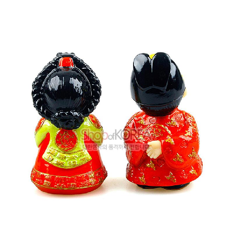 붉은색과 연두색 전통 혼례복에 금색 문양을 채색한 왕과 왕비 민속 인형 장식.