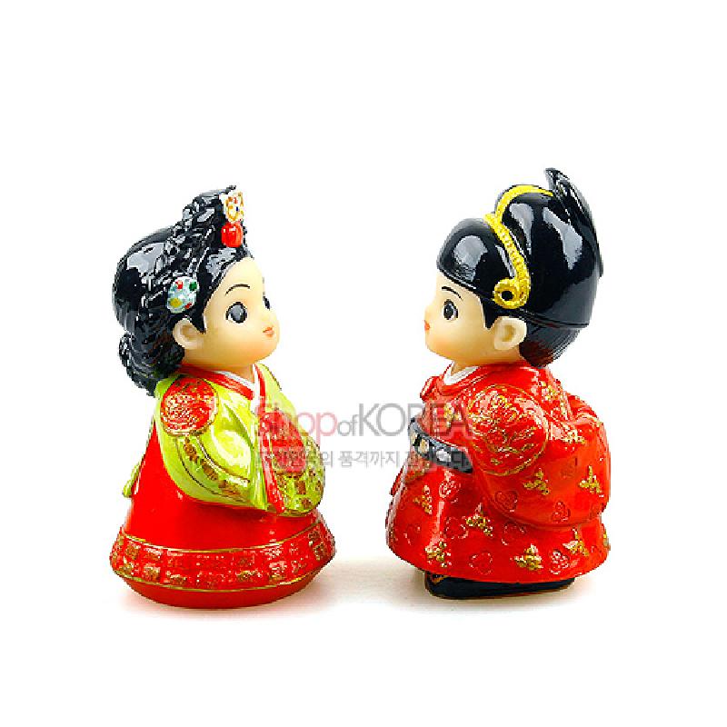 붉은색과 금색 위주의 전통 예복을 입은 왕과 왕비 민속 인형, 금박 무늬와 화려한 머리장식 표현이 특징인 도자 장식품.