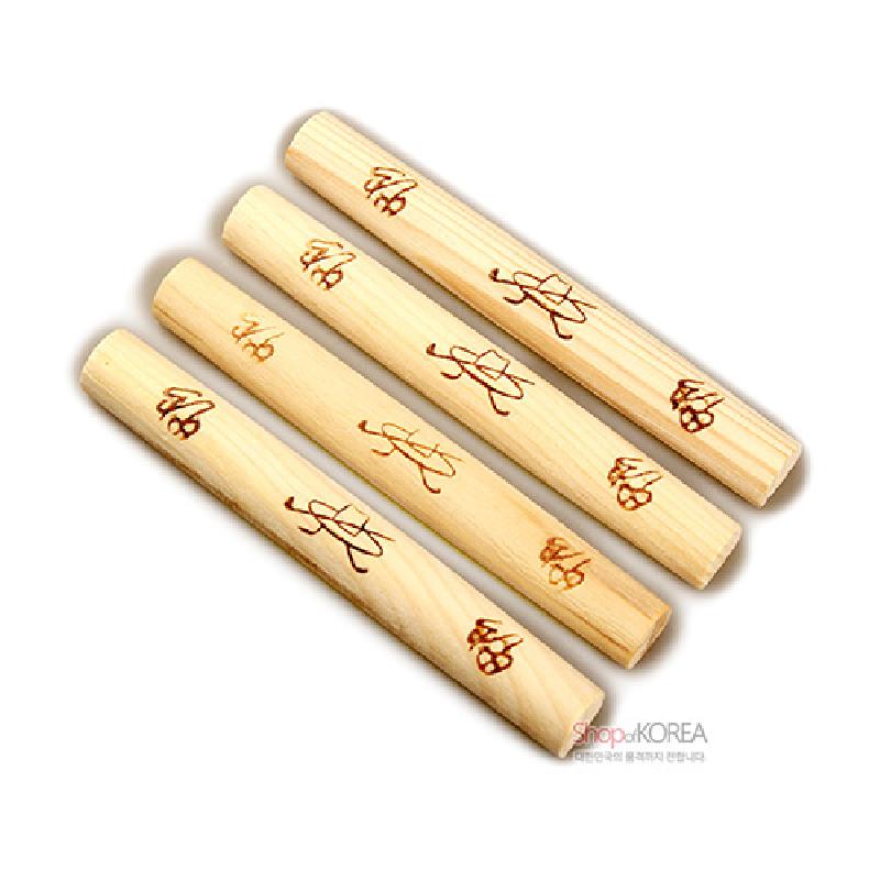 밝은 원목 재질에 갈색 한자 문양을 음각으로 새긴 전통 윷놀이 막대 세트.
