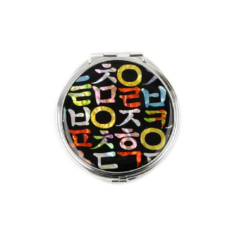 검은 바탕 위에 오색 자개로 상감된 한글 자모 문양이 돋보이는 금속 테두리 원형 손거울.