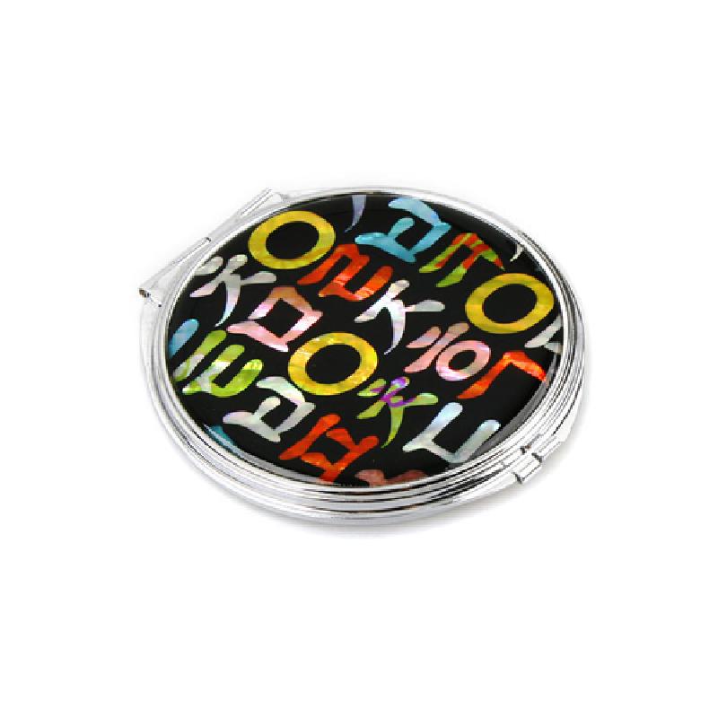 검은 바탕 위에 다채로운 자개 상감으로 한글 자모 문양을 배치한 금속 테두리 손거울.