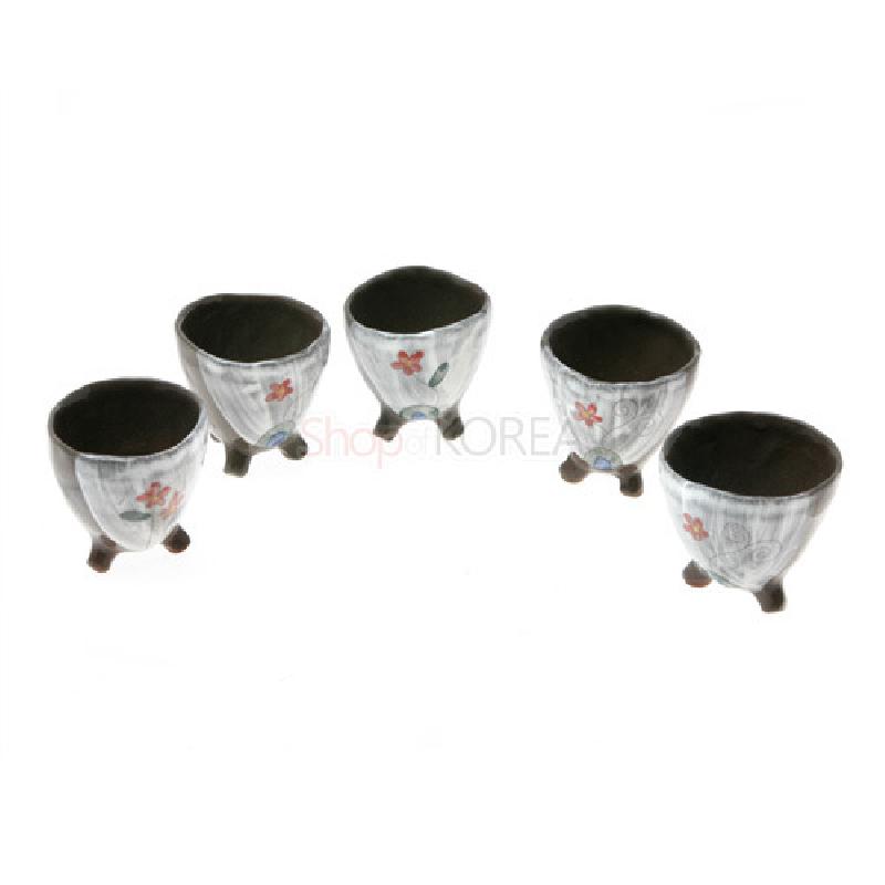 갈색 내면과 삼각형 다리가 있는 도자 재질, 흰 바탕에 야생화와 잎사귀 문양이 수채화처럼 그려진 소주잔 세트.