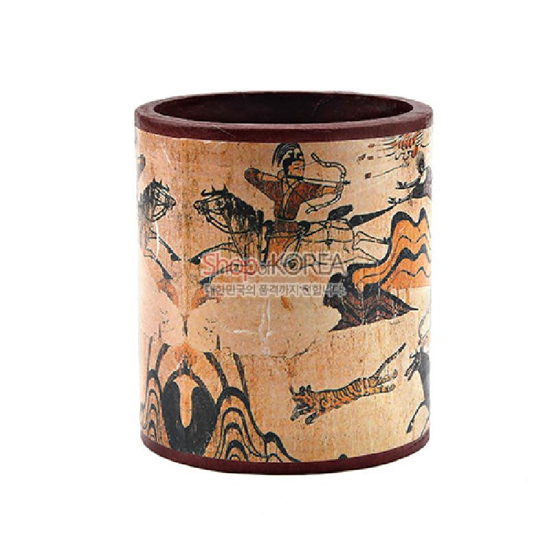 나무 재질에 고구려 수렵도 문양을 인쇄한 원통형 연필꽂이, 갈색과 베이지 색조의 빈티지 질감 장식.