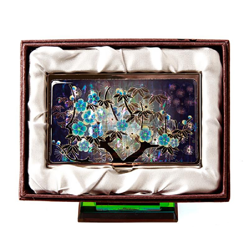 청색 배경 위 자개 상감으로 표현된 매화와 잎사귀 문양이 돋보이는 금속 명함케이스.