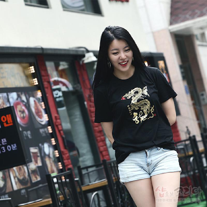 검은색 면 소재 위에 금빛과 흰색 입체발포 기법으로 표현된 용 문양이 특징인 반소매 티셔츠.